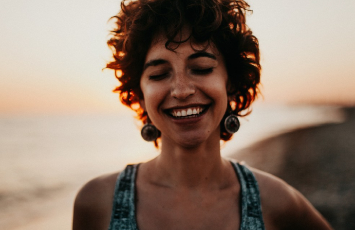 Woman smiling on beach mental health minddemand